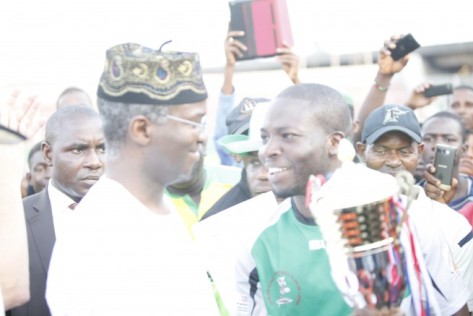Cowrie RFC Captain Azeez Adenopo Receiving the winner's Trophy from then Governor of Lagos State Babatunde Fashola